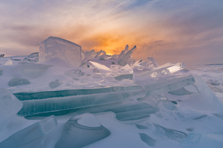 Sunset over breaking Ice in Baikal water lake Russia winter seasonの写真素材