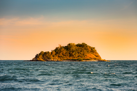 Small island with tropical jungle over ocean skyline, natural landscape backgroundの写真素材