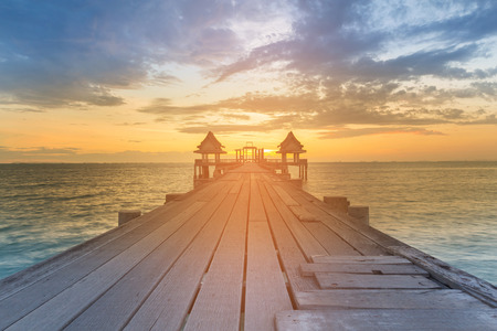 Wooden walking path leading to sunset seacoast skyline, natural landscape backgroundの写真素材