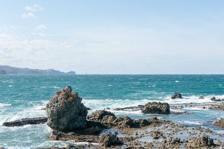Volcano rock on beach with blue skyline, natural landscape backgroundの写真素材