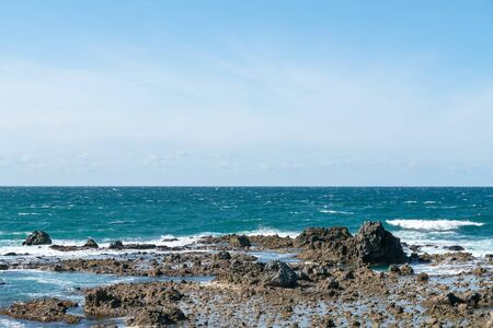 Sea and blue skyline with rock beach, natural landscape background