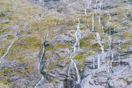 Milford Sound fjord over black rock mountain slope, New Zealand natural landscape background