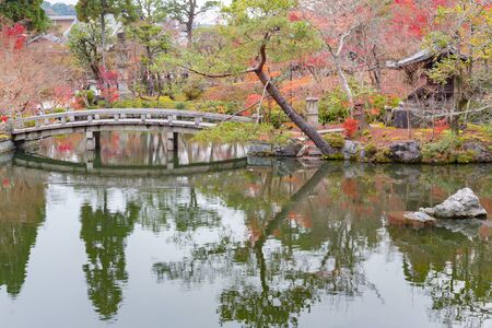 Autumn season public park with stone bridge and water reflection, Japan