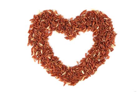 Red rice in heart shape, on white backgroundの写真素材