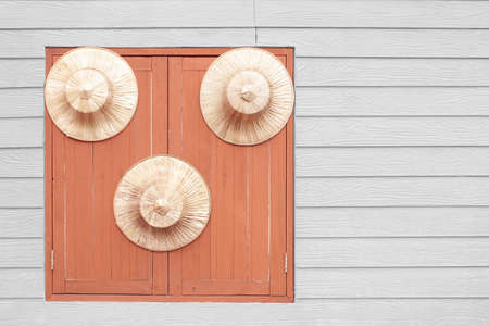 Old country farmer traditional straw hat hanging on the window wallの写真素材