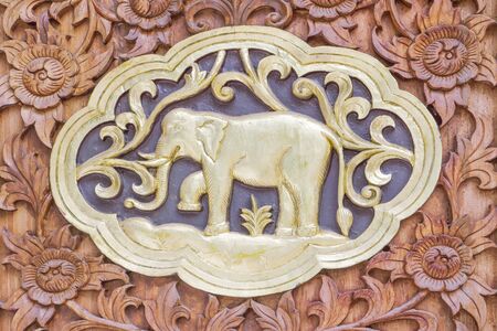 Traditional Thai style wood carving elephant of 12 Zodiac,on the wall of temple in Thailandの写真素材