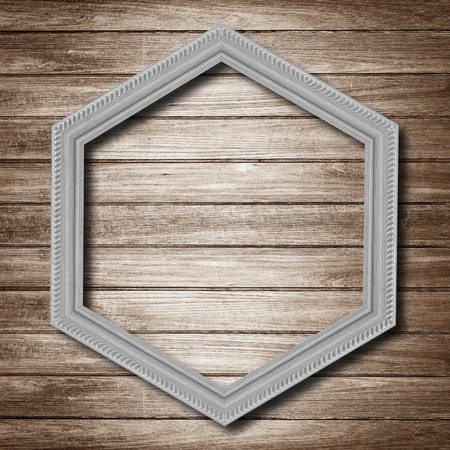 gray wooden hexagonal frame isolated on wood  background.の写真素材