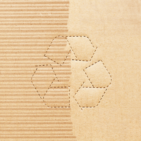 Recycle symbol on torn of cardboard sheet backgroundの写真素材