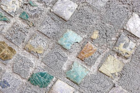 Old ceramic mosaic, loose, cracked, damaged texture backgroundの写真素材