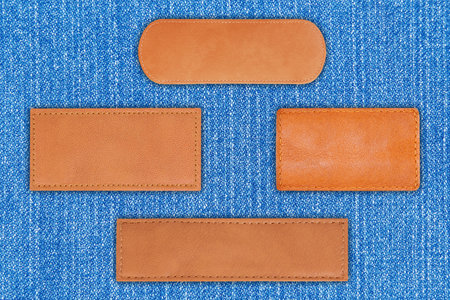 close up label leather collection  on blue Denim or blue Jeans background with clipping pathの写真素材