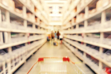 Abstract blurred of shelves in department store with Cart depth focus concept or abstract blur background of supermarket and customerの写真素材
