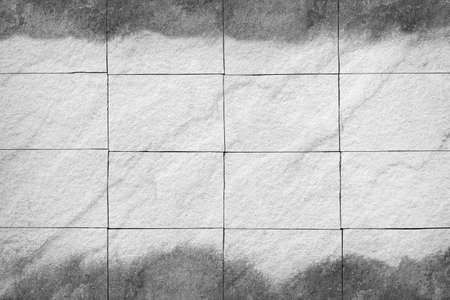 Rough white stone wall with black stain or stone wall tiles texture abstract for background designの写真素材