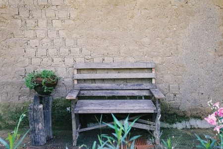 plaster wall from soil backdrop with wooden bench in gardenの写真素材