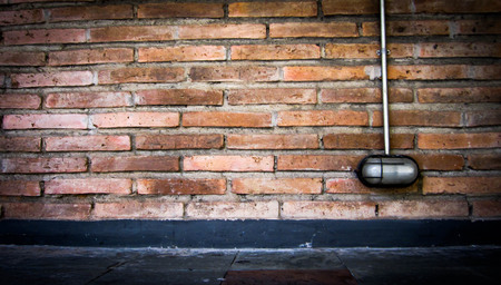 red-brown grung brick wall with lamp On the street.can be used as background