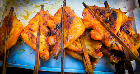 Grilled golden chicken laid on a tray in a restaurant shop in Thailand.の写真素材