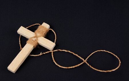Wooden antique look crucifix necklace isolated on black backgroundの写真素材