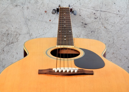 Classic folk guitar on wooden floor and grunge wallの写真素材