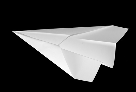 Handmade white origami paper plane isolated on black backgroundの写真素材
