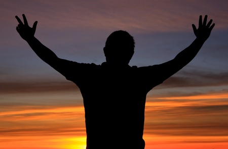 Silhouette of a man with freedom action during sunrise