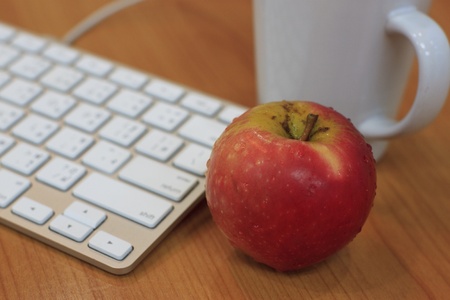 red apple beside the a style keyboard in an office