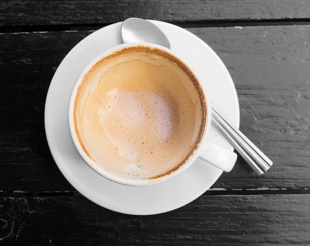 Empty white cup of hot coffee latte on dark wooden table