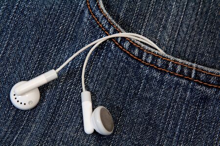 Dark indigo blue jeans with earbud from its pocketの写真素材