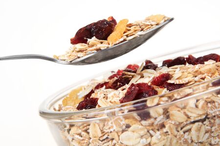 A bowl of American breakfast cereal and dry fruit isolated on white background