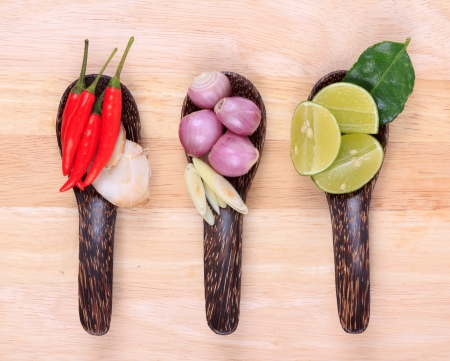 Spicy Thai food ingredients chili, lime,ginger,red onion,lemongrass on wooden background の写真素材