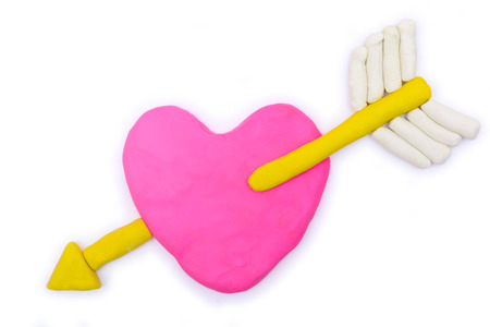 Cupid and pink heart shape plasticine clay on white backgroundの写真素材