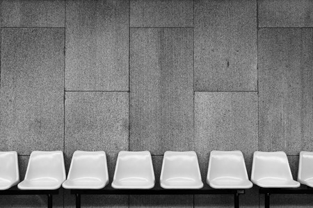 White plastic chairs on cement wallの写真素材