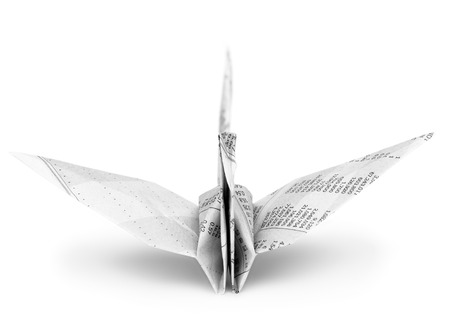 Origami crane bird from recycle newspaper on white backgroundの写真素材