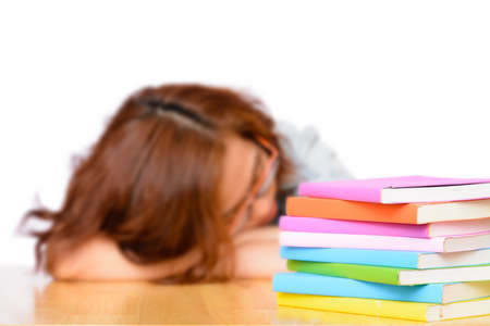 Tired lazy Asian woman sleeping after reading stack of books