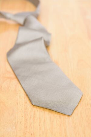 Silver necktie on wooden table backgroundの写真素材