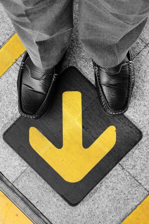 Business man standing on road with direction arrow