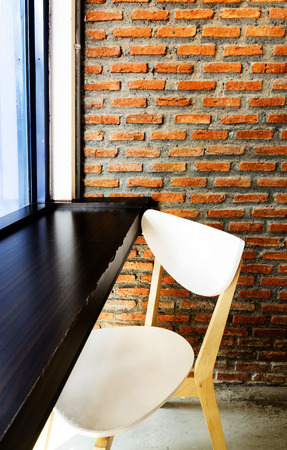 Modern cafe corner with brick wall chair and windowの写真素材
