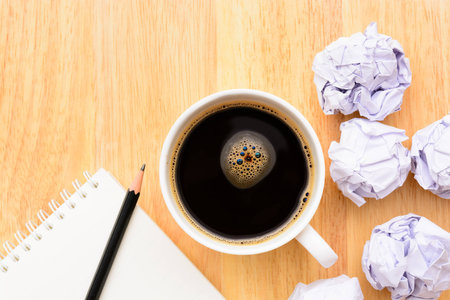 Black coffee and notepad on wooden tableの写真素材