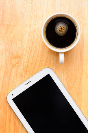 Black coffee and tablet on wooden tableの写真素材
