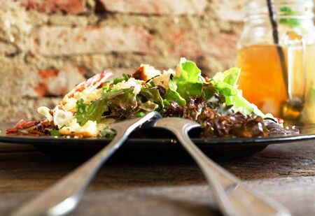 Caesar salad on grunge wooden table and brick wall