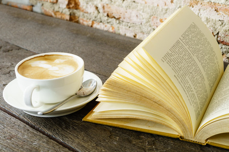 Reading vintage old book and coffeeの写真素材