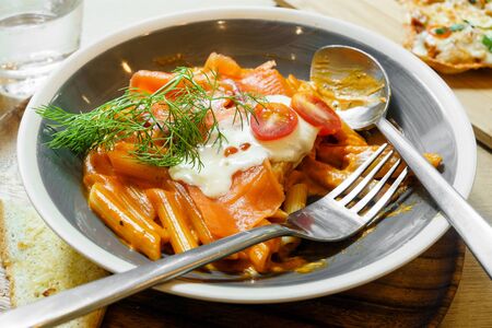Eating fresh salmon penne pastaの写真素材