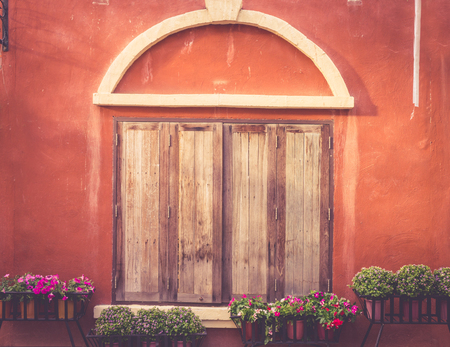 Tuscany wooden window on orange old wallの写真素材