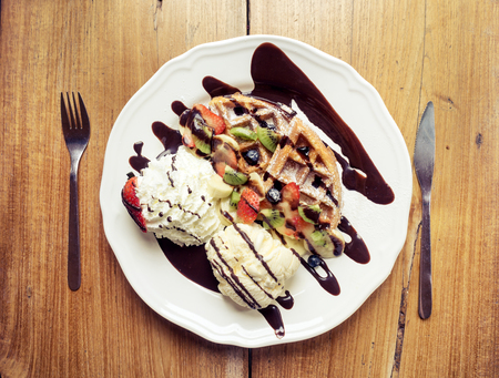 Ice cream waffle with chocolate fudge strawberry berry and kiwiの写真素材