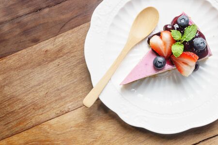 Blue berry cheese cake on wooden deskの写真素材