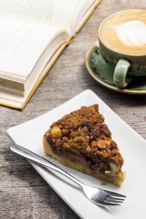 Leisure reading book with apple crumble pie and big coffee latte cupの写真素材