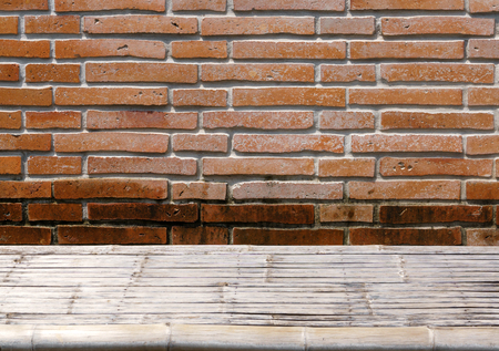Bamboo wicker table on grunge orange brick wallの写真素材