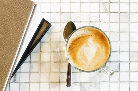 Hot coffee latte cup on white marble tile tableの写真素材