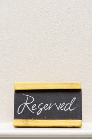 Reserved table sign on white wallの写真素材