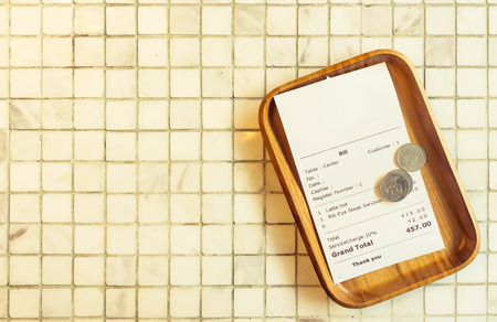 Thai restaurant bill payment receipt on white marble tile table topの写真素材