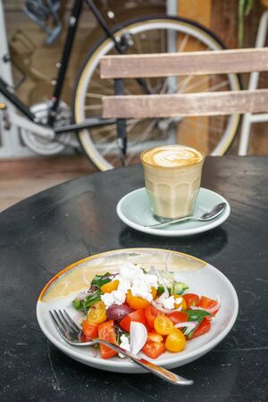 Greek salad and coffee latte for breakfastの写真素材