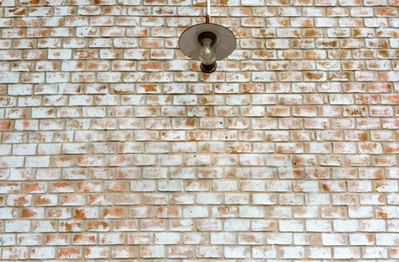 Electricity light lamp bulb on orange white brick wall background textureの写真素材